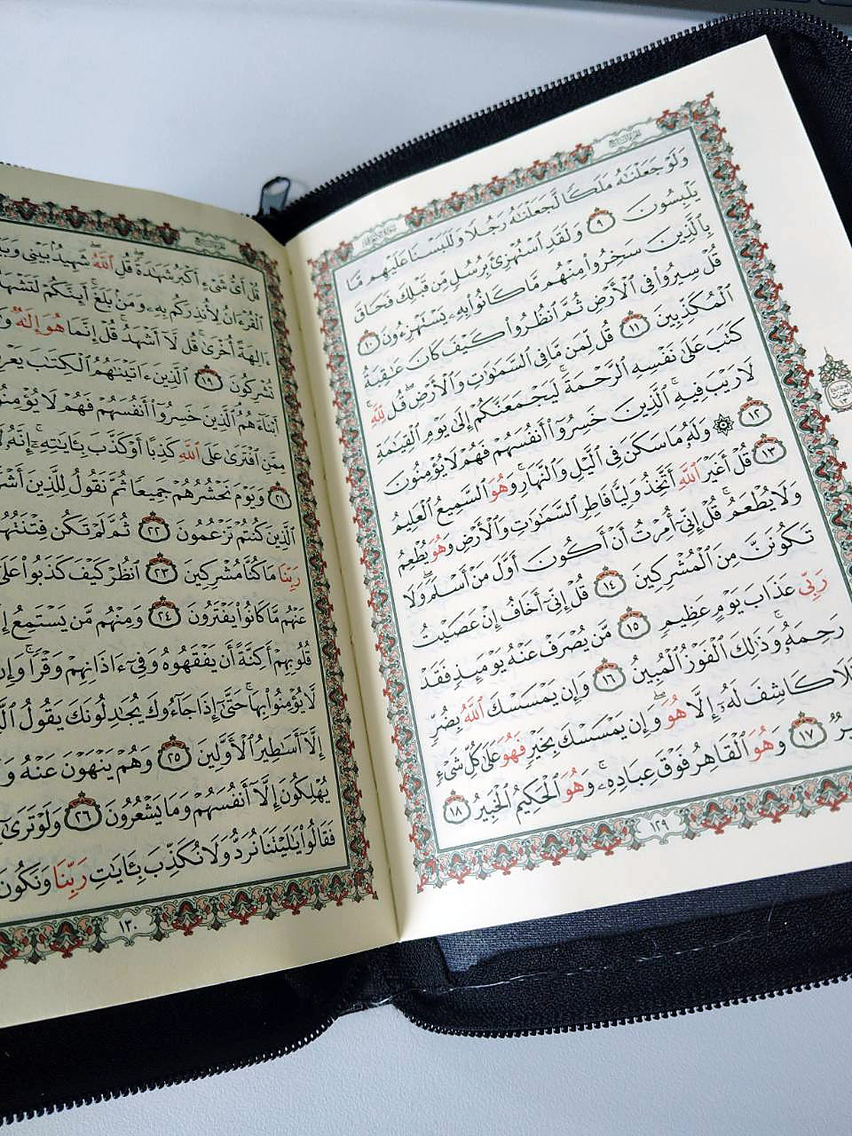 Open Quran showing Arabic text and decorative page borders