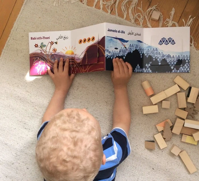 Child exploring the colourful fold-out Islamic Months book